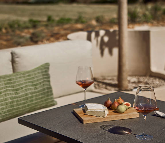 Zelia Resort Halkidiki Zest Pool Bar outdoor couch and a table with two glasses of wine and snacks
