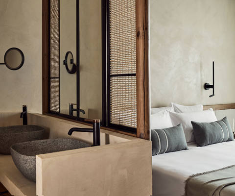 Zelia Resort Halkidiki Deluxe Double two washbasins, a small round mirror and a double bed in the background
