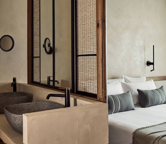 Zelia Resort Halkidiki Deluxe Double two washbasins, a small round mirror and a double bed in the background
