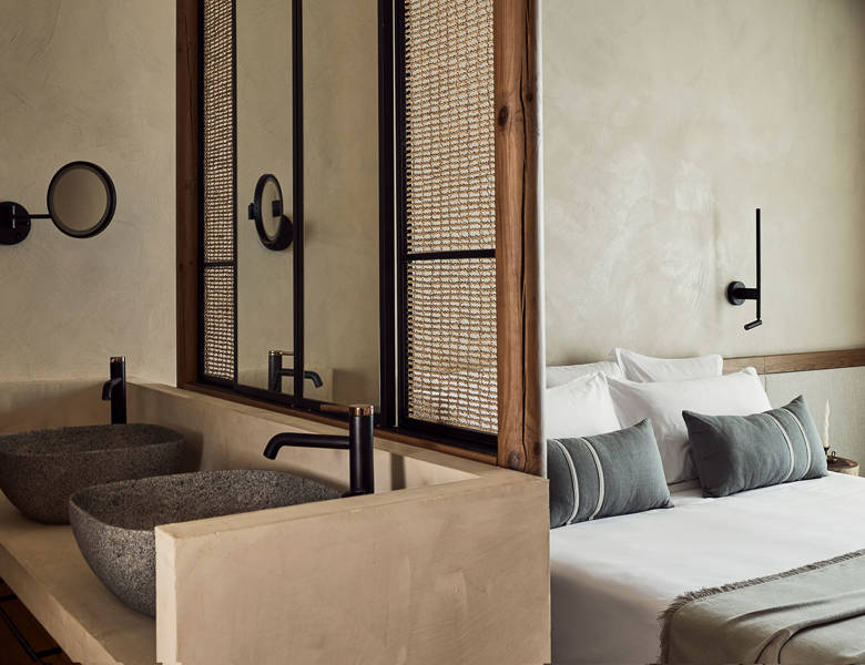 Zelia Resort Halkidiki Deluxe Double two washbasins, a small round mirror and a double bed in the background

